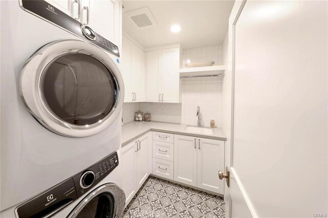 32 Bargemon, Newport Coast, CA 92657 - laundry room featuring stacked washer / dryer and cabinet space