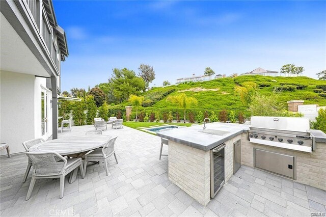 32 Bargemon, Newport Coast, CA 92657 - view of patio / terrace featuring wine cooler, outdoor dining space, a sink, and a pool