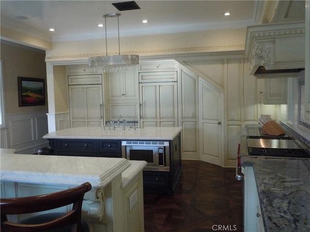 59 Rivo Alto Canal, Long Beach, CA 90803 - kitchen with a decorative wall, stainless steel microwave, a kitchen island, ornamental molding, and hanging light fixtures