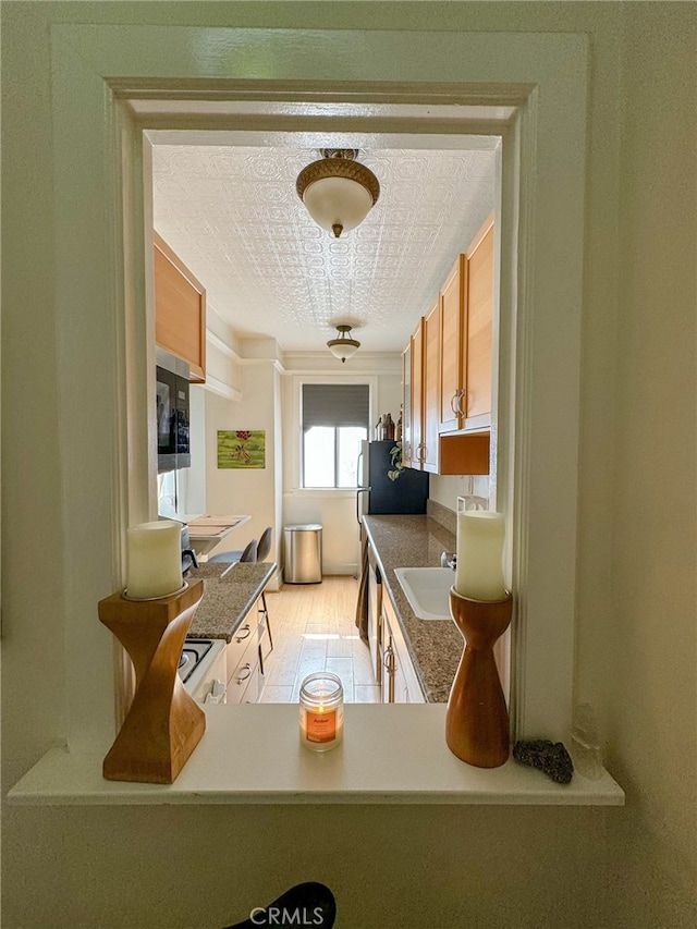 315 W 3rd St Unit 203, Long Beach, CA 90802 - kitchen with a sink, brown cabinetry, dark countertops, and stainless steel microwave