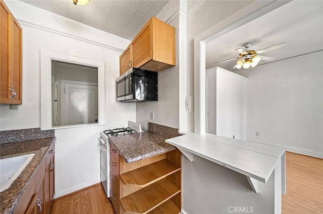 315 W 3rd St Unit 203, Long Beach, CA 90802 - kitchen with stainless steel appliances, light wood-style flooring, a peninsula, ceiling fan, and open shelves