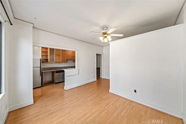315 W 3rd St Unit 203, Long Beach, CA 90802 - kitchen with appliances with stainless steel finishes, a ceiling fan, light wood finished floors, baseboards, and brown cabinetry