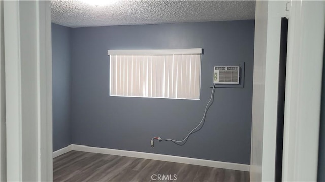 7107 Coldwater Canyon Ave, North Hollywood, CA 91605 - empty room featuring dark wood-style flooring, a textured ceiling, a wall mounted AC, and baseboards