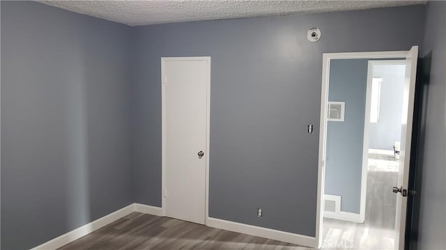 7107 Coldwater Canyon Ave, North Hollywood, CA 91605 - unfurnished room featuring wood finished floors, a textured ceiling, a smoke detector, and baseboards