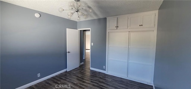 7107 Coldwater Canyon Ave, North Hollywood, CA 91605 - unfurnished bedroom with a chandelier, dark wood finished floors, a textured ceiling, baseboards, and a closet