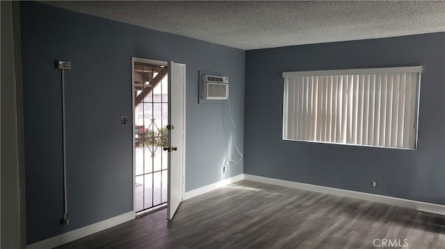 7107 Coldwater Canyon Ave, North Hollywood, CA 91605 - empty room with wood finished floors, a textured ceiling, an AC wall unit, and baseboards