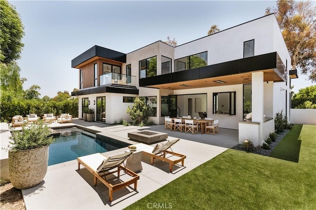 2321 Mesa Dr, Newport Beach, CA 92660 - back of property with a balcony, an outdoor living space with a fire pit, an outdoor pool, and a patio