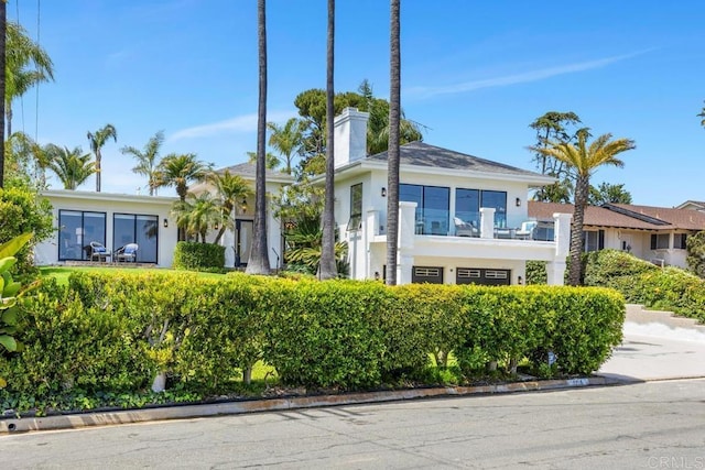 5918 Germaine Ln, La Jolla, CA 92037 - view of front of house featuring a chimney, stucco siding, and a balcony