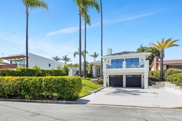 5918 Germaine Ln, La Jolla, CA 92037 - view of front facade featuring an attached garage, concrete driveway, a balcony, and stucco siding