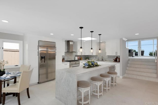 5918 Germaine Ln, La Jolla, CA 92037 - kitchen with high end appliances, wall chimney exhaust hood, a sink, white cabinets, and recessed lighting