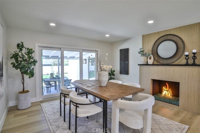 13181 Olympia Way N, Tustin, CA 92705 - dining space with light wood-style floors, recessed lighting, a lit fireplace, and baseboards