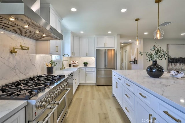 13181 Olympia Way N, Tustin, CA 92705 - kitchen featuring wall chimney range hood, stainless steel appliances, a sink, white cabinets, and recessed lighting