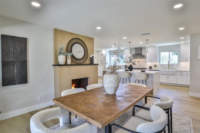 13181 Olympia Way N, Tustin, CA 92705 - dining room with baseboards, light wood finished floors, recessed lighting, and a large fireplace