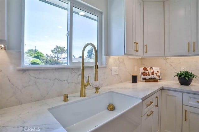 13181 Olympia Way N, Tustin, CA 92705 - kitchen with a sink, decorative backsplash, light stone countertops, and white cabinets