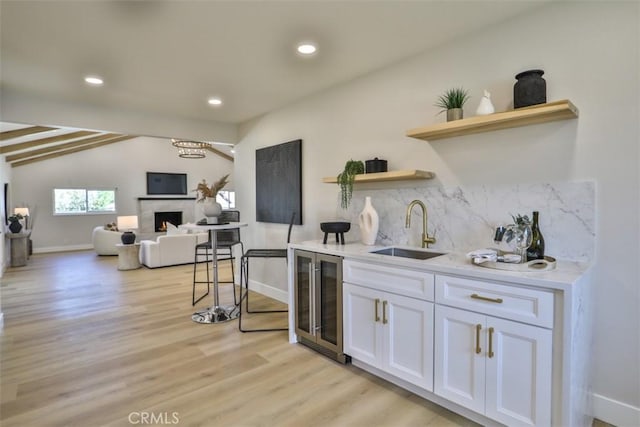 13181 Olympia Way N, Tustin, CA 92705 - kitchen with wine cooler, a sink, open shelves, decorative backsplash, and white cabinetry