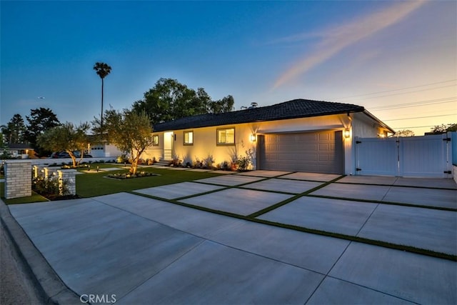 13181 Olympia Way N, Tustin, CA 92705 - single story home with a gate, an attached garage, a front lawn, concrete driveway, and stucco siding
