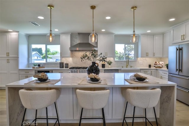 13181 Olympia Way N, Tustin, CA 92705 - kitchen featuring appliances with stainless steel finishes, wall chimney range hood, a sink, healthy amount of natural light, and recessed lighting