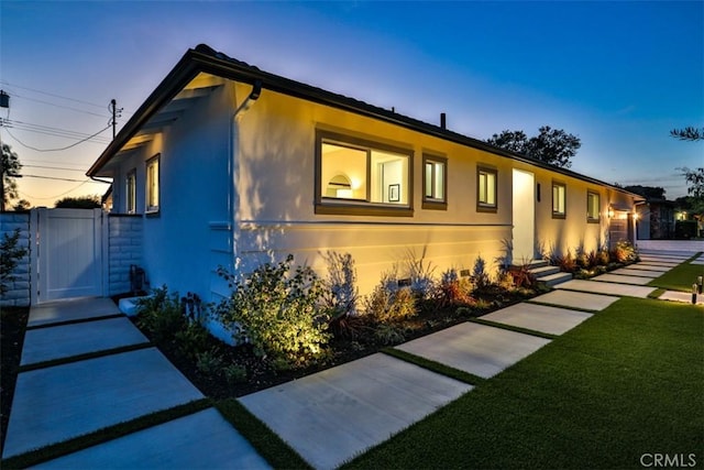 13181 Olympia Way N, Tustin, CA 92705 - view of front facade with stucco siding, a front yard, and a gate