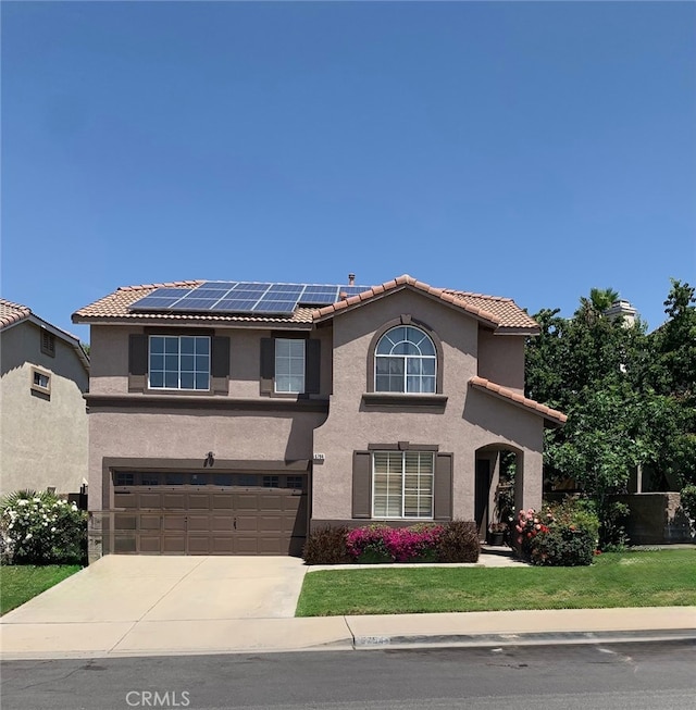 5794 Bay Hill Ln, Fontana, CA 92336 - view of front facade featuring a tile roof, stucco siding, roof mounted solar panels, and driveway