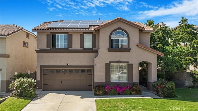 5794 Bay Hill Ln, Fontana, CA 92336 - view of front of home featuring stucco siding, a tile roof, concrete driveway, solar panels, and a garage