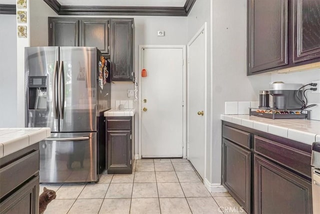 5794 Bay Hill Ln, Fontana, CA 92336 - kitchen featuring stainless steel refrigerator with ice dispenser, tile countertops, ornamental molding, light tile patterned floors, and dark brown cabinetry