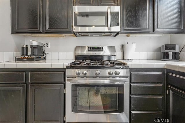 5794 Bay Hill Ln, Fontana, CA 92336 - kitchen featuring appliances with stainless steel finishes, tile counters, and dark brown cabinetry