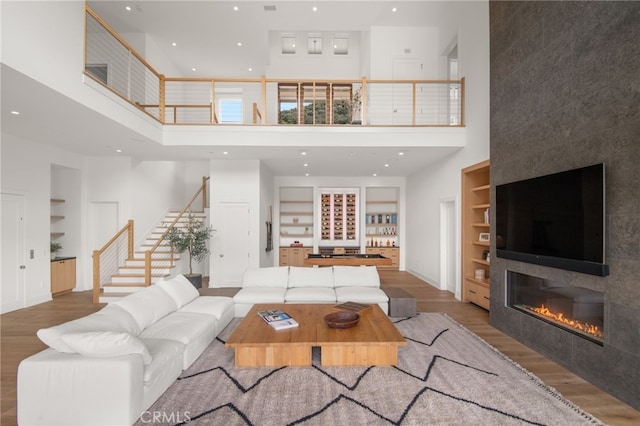 2775 Calbourne Ln, Westlake Village, CA 91361 - living room with a towering ceiling, built in features, wood finished floors, stairway, and recessed lighting
