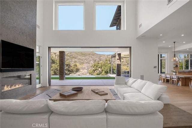2775 Calbourne Ln, Westlake Village, CA 91361 - living area with wood finished floors, a towering ceiling, and a glass covered fireplace