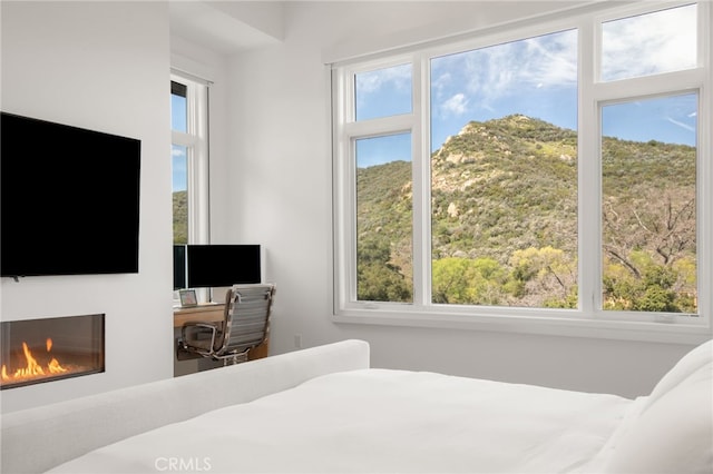 2775 Calbourne Ln, Westlake Village, CA 91361 - bedroom featuring multiple windows, a glass covered fireplace, and an office area