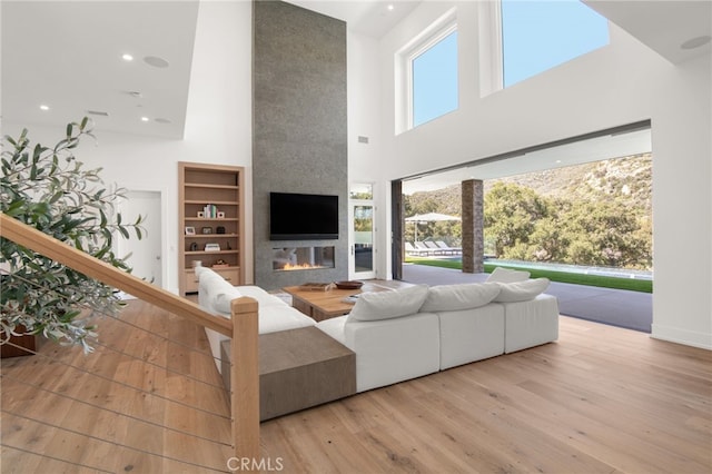 2775 Calbourne Ln, Westlake Village, CA 91361 - living room featuring a high ceiling, a large fireplace, wood-type flooring, and recessed lighting
