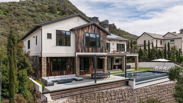 2775 Calbourne Ln, Westlake Village, CA 91361 - back of property featuring a jacuzzi, outdoor lounge area, a patio, a chimney, and a deck