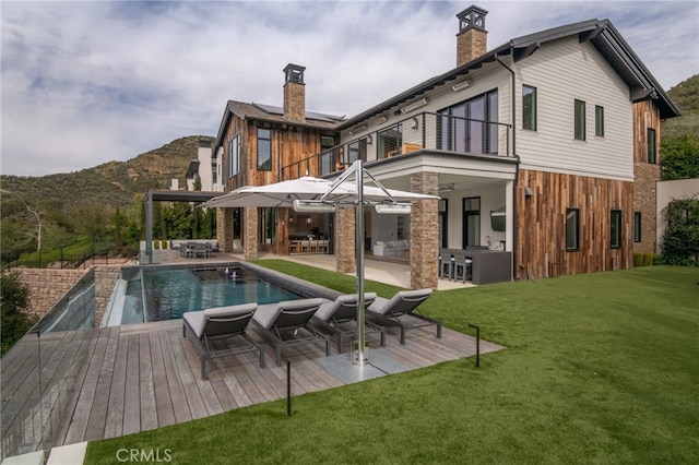 2775 Calbourne Ln, Westlake Village, CA 91361 - rear view of property with a balcony, a chimney, a yard, an outdoor pool, and a mountain view