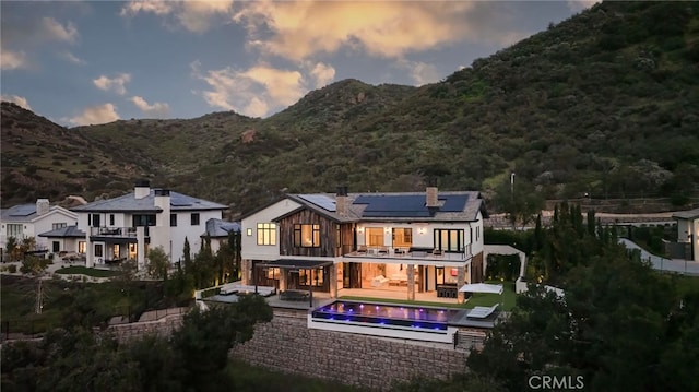 2775 Calbourne Ln, Westlake Village, CA 91361 - back of property with solar panels, a balcony, a chimney, a patio area, and a mountain view
