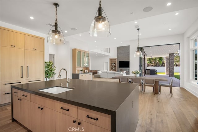 2775 Calbourne Ln, Westlake Village, CA 91361 - kitchen with a sink, light brown cabinetry, dark countertops, an island with sink, and light wood-type flooring