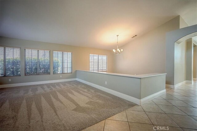 24347 Silver Bullet Way, Murrieta, CA 92562 - spare room with lofted ceiling, arched walkways, a chandelier, baseboards, and light colored carpet