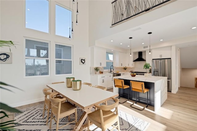 1802 Blossom Ln, Redondo Beach, CA 90278 - dining room featuring light wood-type flooring, a towering ceiling, and recessed lighting