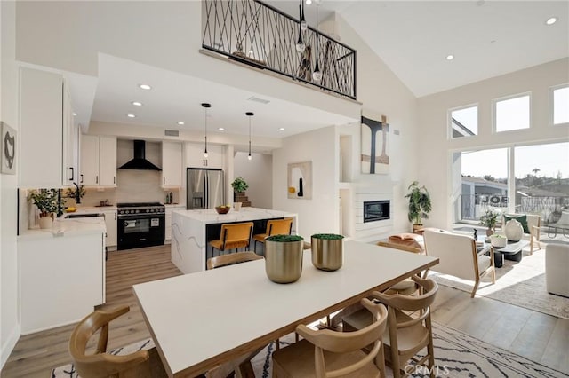 1802 Blossom Ln, Redondo Beach, CA 90278 - dining area with high vaulted ceiling, light wood finished floors, a glass covered fireplace, and recessed lighting