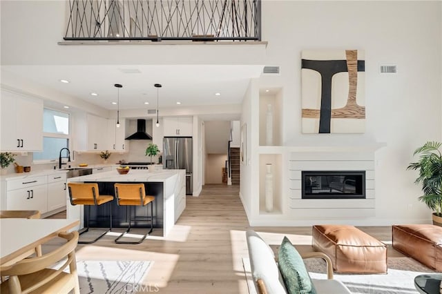 1802 Blossom Ln, Redondo Beach, CA 90278 - living area with light wood-type flooring, a glass covered fireplace, a high ceiling, and recessed lighting