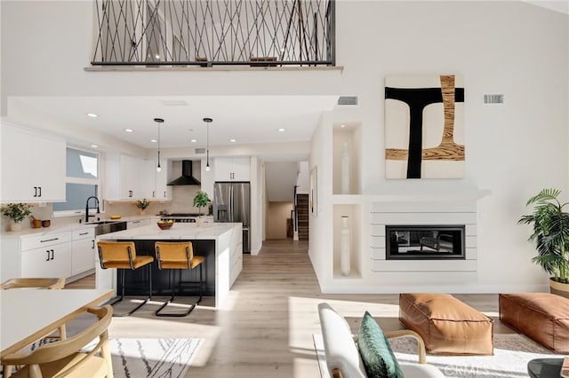 1802 Blossom Ln, Redondo Beach, CA 90278 - living area with light wood-style floors, a towering ceiling, a glass covered fireplace, and recessed lighting