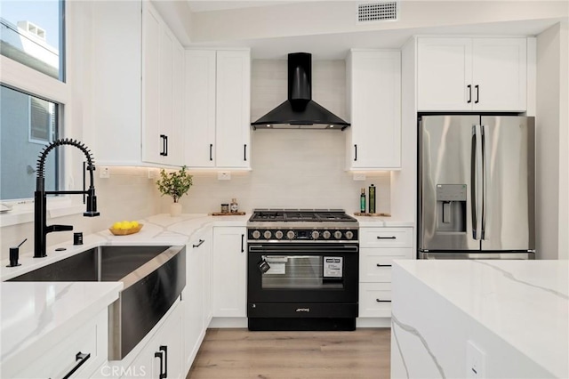 1802 Blossom Ln, Redondo Beach, CA 90278 - kitchen featuring stainless steel refrigerator with ice dispenser, high end black range oven, wall chimney exhaust hood, light stone counters, and white cabinets