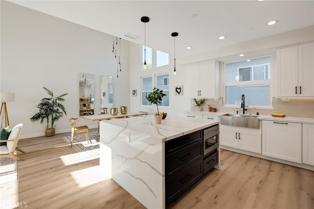 1802 Blossom Ln, Redondo Beach, CA 90278 - kitchen with light wood-type flooring, white cabinetry, pendant lighting, recessed lighting, and stainless steel microwave