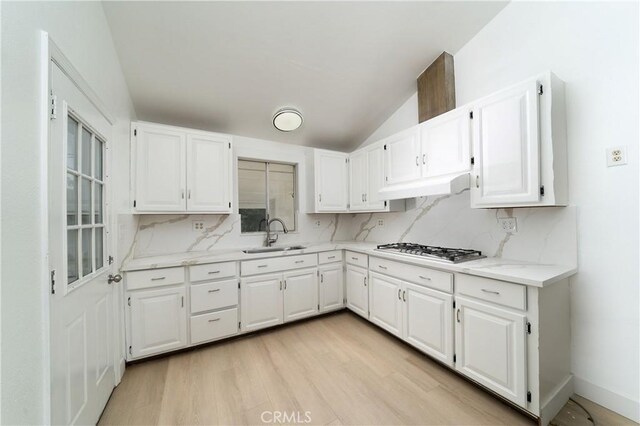 15251 Cedarwood Ave, Midway City, CA 92655 - kitchen featuring a sink, stainless steel gas cooktop, white cabinetry, under cabinet range hood, and light wood-style flooring