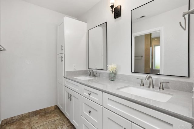 2345 Levante St, Carlsbad, CA 92009 - bathroom with double vanity, stone tile flooring, and baseboards