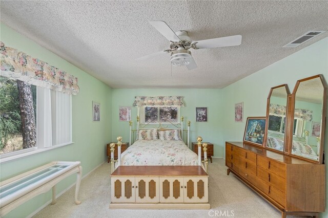 37731 Shoreline Dr, Bass Lake, CA 93604 - carpeted bedroom with multiple windows, a textured ceiling, ceiling fan, and baseboards