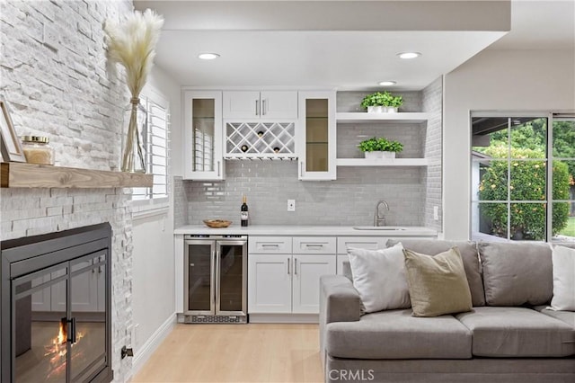 8426 Orange St, Downey, CA 90242 - indoor wet bar featuring beverage cooler, a fireplace, backsplash, light wood-type flooring, and recessed lighting