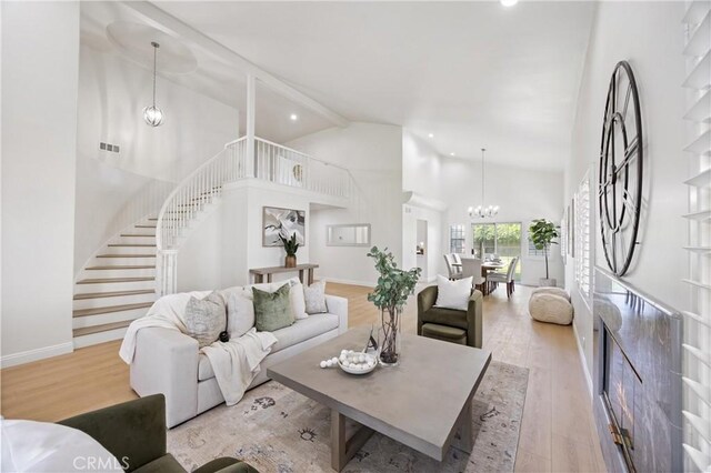 8426 Orange St, Downey, CA 90242 - living area featuring high vaulted ceiling, stairway, a chandelier, wood finished floors, and recessed lighting