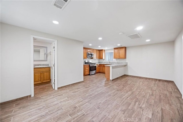 8426 Orange St, Downey, CA 90242 - kitchen with stainless steel appliances, light wood finished floors, light countertops, recessed lighting, and brown cabinets