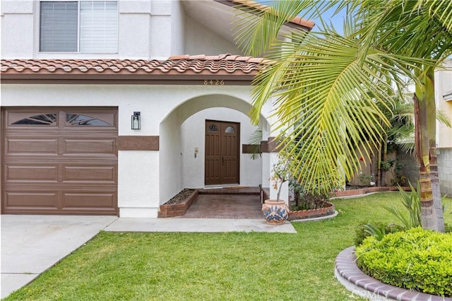 8426 Orange St, Downey, CA 90242 - doorway to property with an attached garage, stucco siding, a yard, and driveway