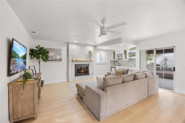 8426 Orange St, Downey, CA 90242 - living area with light wood-style flooring, ceiling fan, a stone fireplace, healthy amount of natural light, and recessed lighting