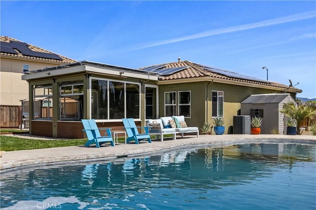 283 Katie Ct, Lakeport, CA 95453 - back of property with a sunroom, roof mounted solar panels, an outdoor pool, a tile roof, and stucco siding